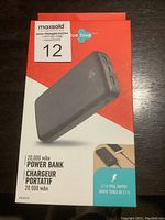 Full front of the unopened retail box showing the power bank image and features like 20,000mAh capacity, 2.1A total output, and dual port charging support.