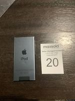 Back of blue Apple iPod Nano with visible Apple logo and iPod text, placed next to a MaxSold label showing number 20.