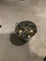 Corona Extra bucket on floor, 3/4 full of coins
