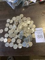 A heap of 79 Canadian five-cent coins on a dark surface with a MaxSold lot card visible.