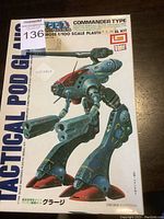 Box front photo showing the Macross Tactical Pod Commander Type 1/100 scale plastic model kit artwork and branding.