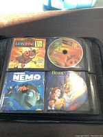 Close-up photo of DVD binder page containing The Lion King 1½ disc and cover, Finding Nemo, and Beauty and the Beast Special Edition disc covers