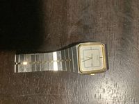 Full view of vintage Seiko wristwatch on wooden surface showing the entire watch and band.