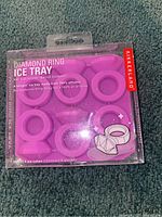 Purple silicone ice cube tray for making diamond ring shaped ice cubes in its original packaging.