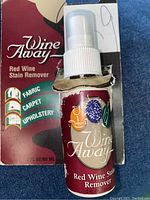 Spray bottle with label showing Wine Away Red Wine Stain Remover for fabric, carpet, upholstery.