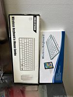 Photo showing two boxes, one for a wireless keyboard and mouse combo, English keyboard, and one for a wireless Bluetooth keyboard.