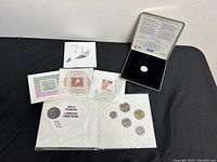 Photo showing multiple Canadian coins in protective keepsake folder and stamp mounts.