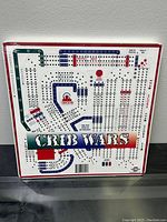 Front view of sealed Crib Wars game box showing the printed game board with paths and game markings.