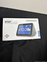 Closed box of Lenovo Smart Clock with printed image and branding on front.