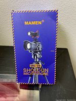 Box front showing Mamen MIC-08 shotgun microphone mounted on a camera tripod.