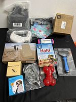 Photo showing all items in the lot, new condition, including various collars, grooming tools, bowls, and toys.