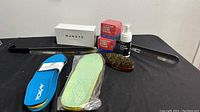 Photo showing all shoe accessories including shoe horn, insoles, cleaning foam, shoe cream, brush, and Mendoza box.
