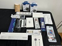 Various new watch bands and earbud cases arranged on a table, showing product packaging and labels.