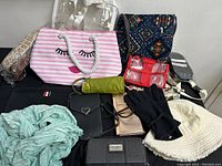 Overview of lot showing various purses, bags, a scarf, gloves, and hat