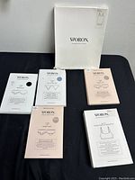Five Woron apparel items in packaging, including three different undergarments and bralettes, all new with original branding and information.