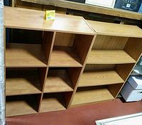 Photo showing two wooden bookcases side by side, one with 6 cube compartments and the other with 4 shelves