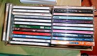 Photo showing 25 music CD cases in a box, including titles by Clay Aiken, Ice Castles soundtrack, Carrie Underwood, classic and Christmas themed albums