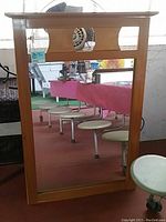 Front view of maple wood bureau table top mirror showing full mirror and cut-out slots at the top of the frame.
