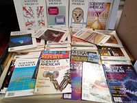 Overall lot view of 27 Scientific American magazines with covers showing various scientific topics from 1977 through the 2000s.