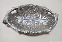 Top angle view of the silver grape leaf serving dish showing detailed grapevine embossing and integral handles.