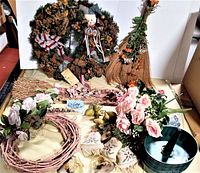 Wide view of lot including large wreath, broom decoration, small flowers, fruit picks, grapevine wreaths, ribbons and floral base holder
