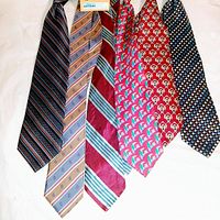 Top side view of six men's ties laid out flat, showing patterns and colors.