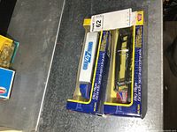 Two die cast Cold GT Trans big rig trucks in original unopened boxes, shown side by side on a metallic surface.