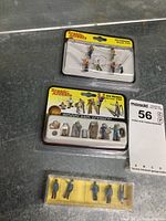 Three packages of HO Scale figures by Scenic Accents and one unbranded, displayed on a grey surface with a MaxSold note.