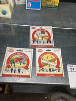 Three unopened packages of HO scale model railroad figures, labeled Train Crew, Station Service Crew, and Track Laying Crew by Model Power on a gray surface.