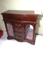 Photo of the closed wooden jewelry box with dark polished wood and brass hardware