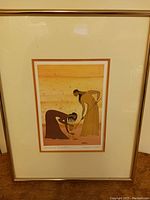 Framed art print showing entire piece with gold-colored thin frame and off-white matting around the image of two women titled "Working Together".