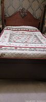 Full view of the king size quilt on a bed showing patchwork squares and appliqué border.