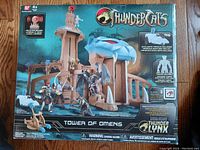 Box front showing the Tower of Omens playset with figures displaying the scale and features, including logos and brand information.