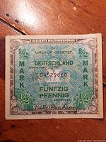 Front image of the WWII 1944 Allied Military Government 1/2 Mark Fünfzig Pfennig banknote showing denomination, serial number, and official markings.