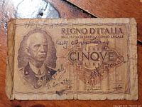 Front view of heavily worn 5 Lire banknote featuring King Vittorio Emanuele III portrait with signatures and historical Italian text.
