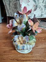 Front view of vintage Italian Capodimonte porcelain floral figurine with multicolored gold-tipped flowers and leafy base.