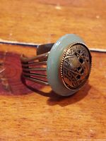 Close-up side angle showing the bronze and jade round bezel and expandable bronze band.