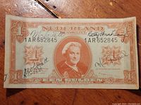 Front view of the Netherlands one gulden banknote from 1945 showing Queen Wilhelmina portrait with some handwriting visible.