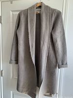 Taupe Pink Martini weighted sweater coat with open front hanging on door