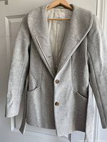 Wilfred grey virgin wool/cashmere coat hanging on door showing front buttons and collar detail.