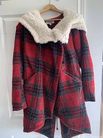 Red plaid ladies winter coat with faux fur fleece lining and hood, hanging on a door