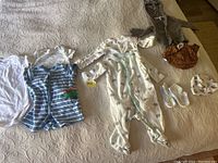 All 6 month baby clothes items displayed on bed