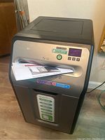 Full front image of GoECOlife GXC185P shredder powered on with included paperwork in the input slot.