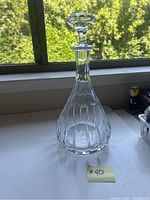 Full view of crystal decanter showing shape, stopper, and overall size against a window background.