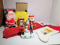 Full lot view including walking Santa, snowman music box, tree skirt, stocking, and other decorations.