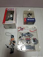 Assortment showing nutcracker style ornament, team ornament in box, and NFL Team Sign Ornaments pack
