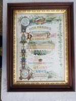 Front view of the framed Lord's Prayer print showing colorful text and floral designs within a gold-accented wooden frame.