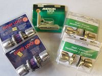 Full view of entire lot showing two E-Z Set Entry Locksets in blue packaging, two Gate House Hall/Closet Locksets in green packaging, and one American Lock Steel Hasp in green packaging.