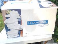 Box of Corningware French White 15-piece cookware set with faded printing, showing product images and branding.
