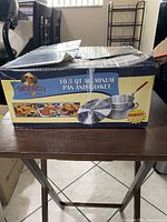 Box showing product branding and image of aluminum pan with basket and lid